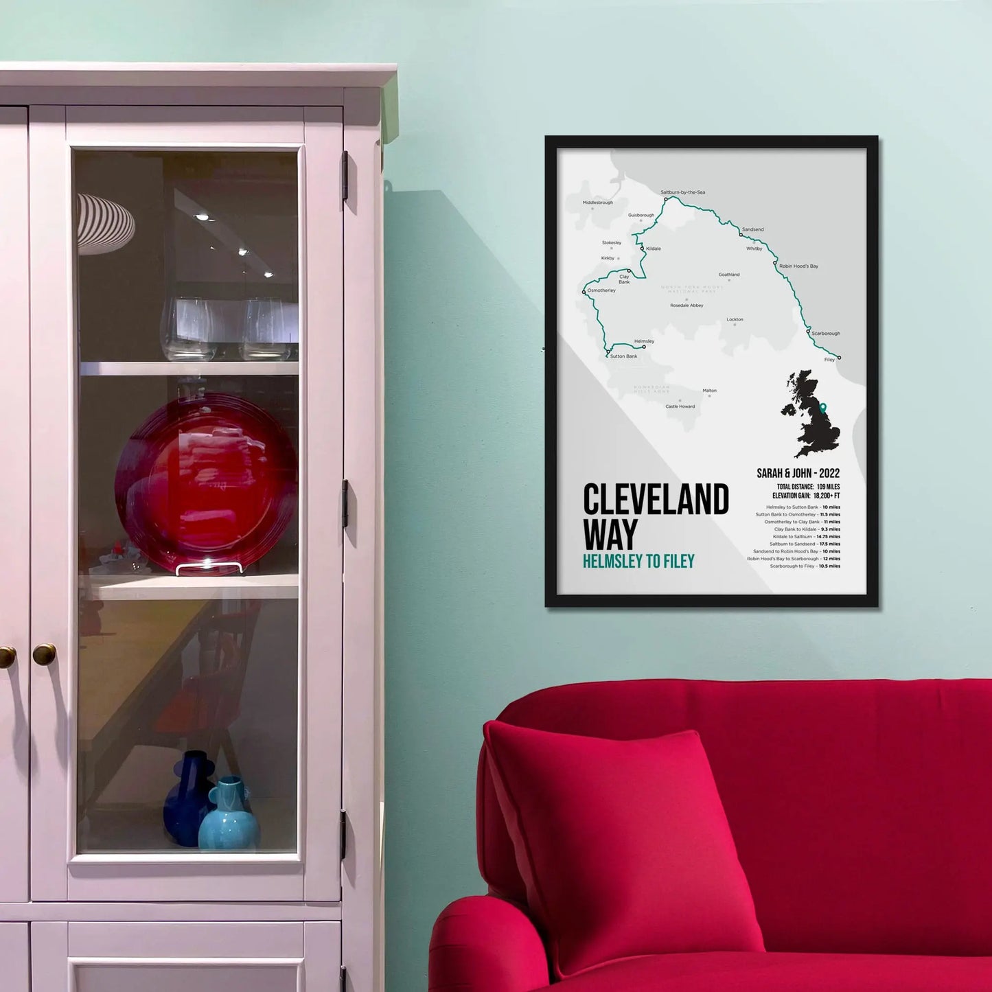 Framed print on wall beside a pink shelving unit