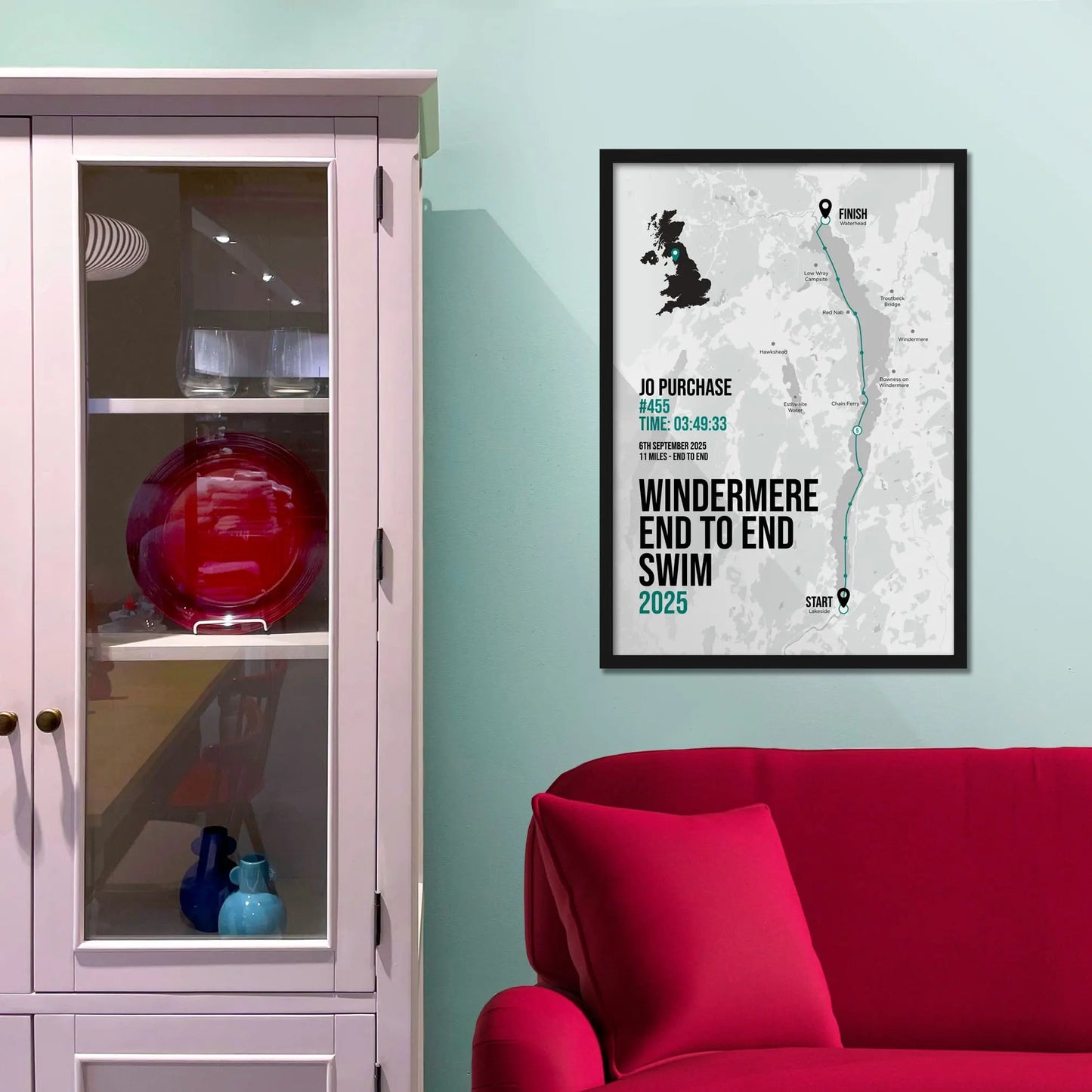 Framed picture on a baby blue wall beside pink shelving