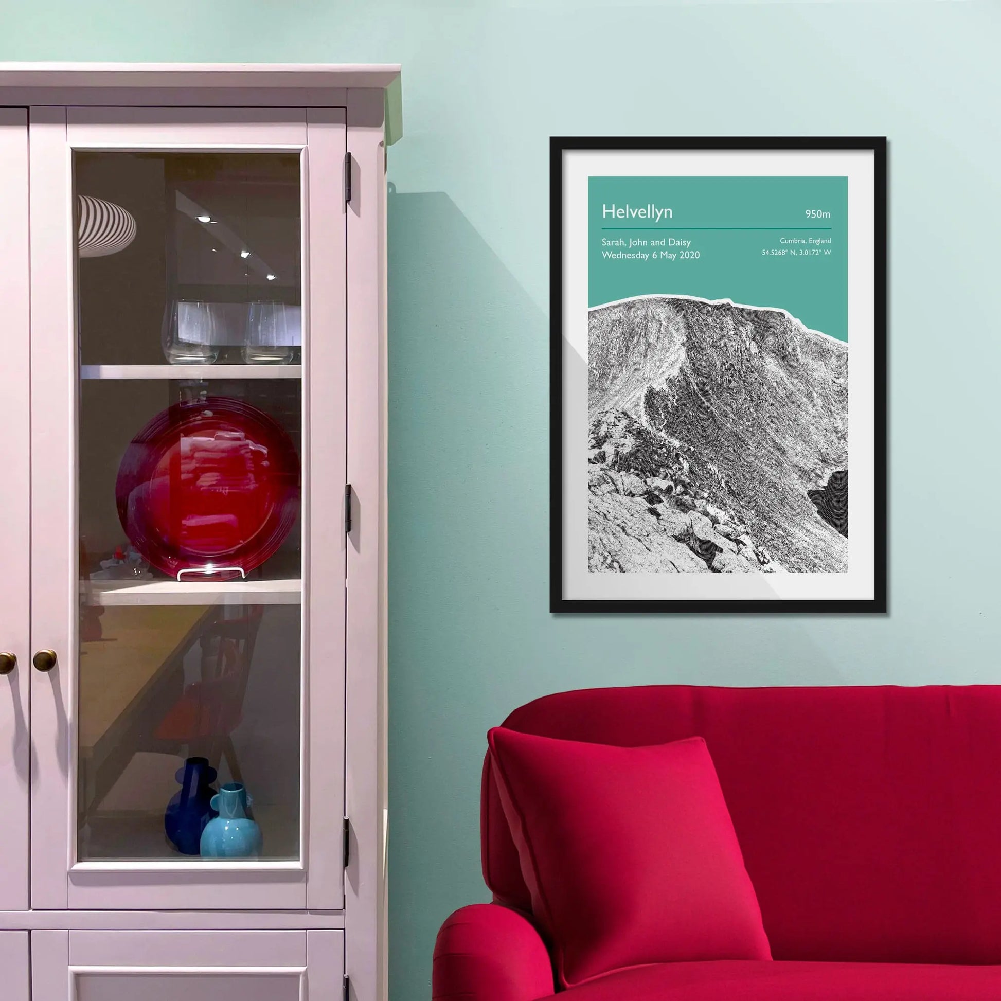 Framed picture on a baby blue wall beside pink shelving