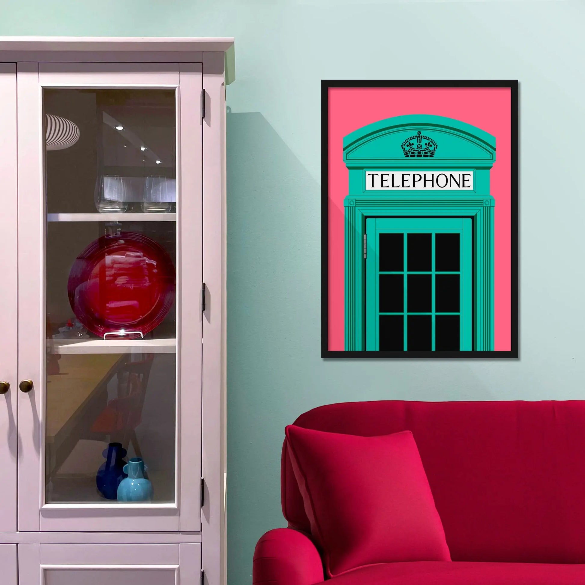 Framed picture on a baby blue wall beside pink shelving