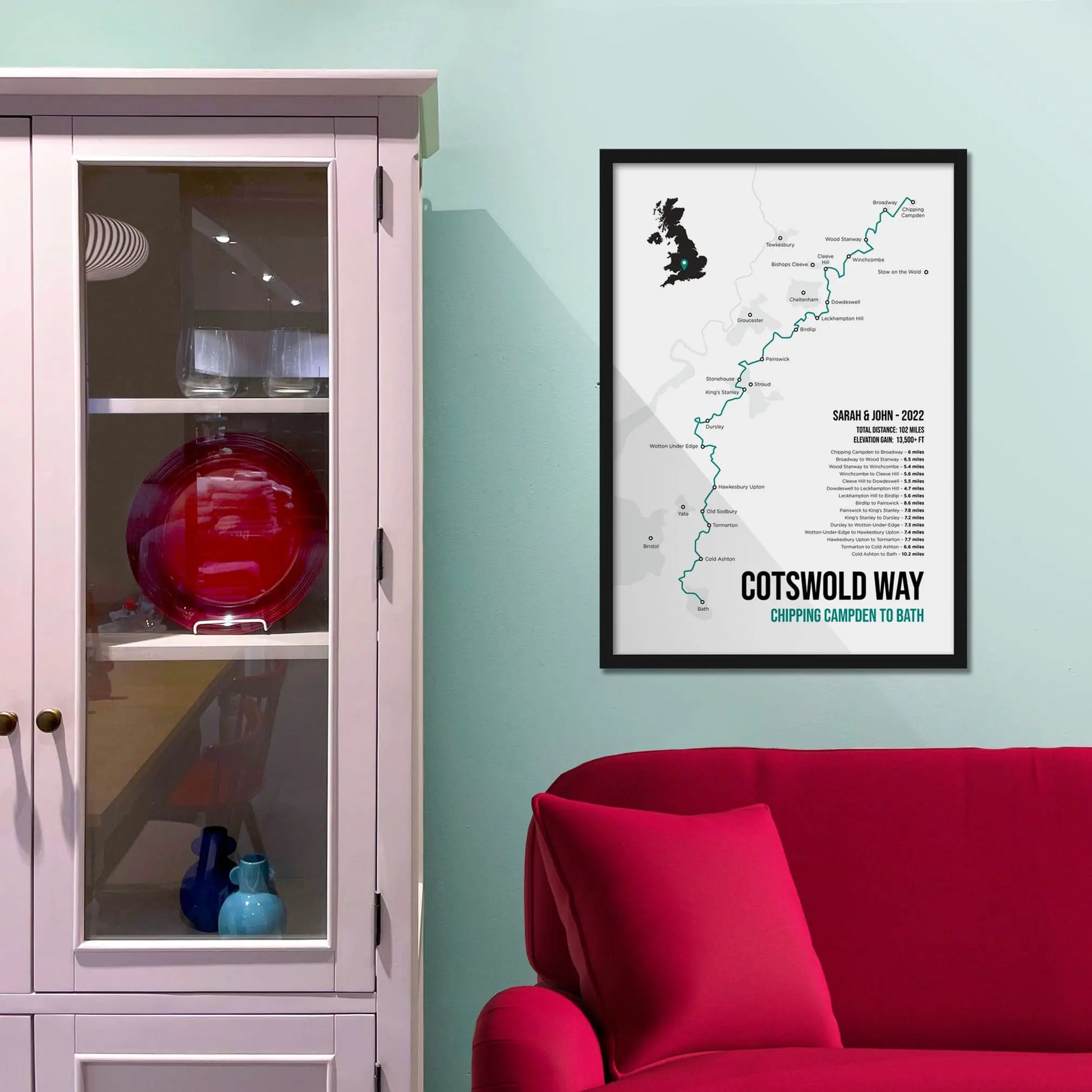 Framed print on light blue wall beside pink shelving unit