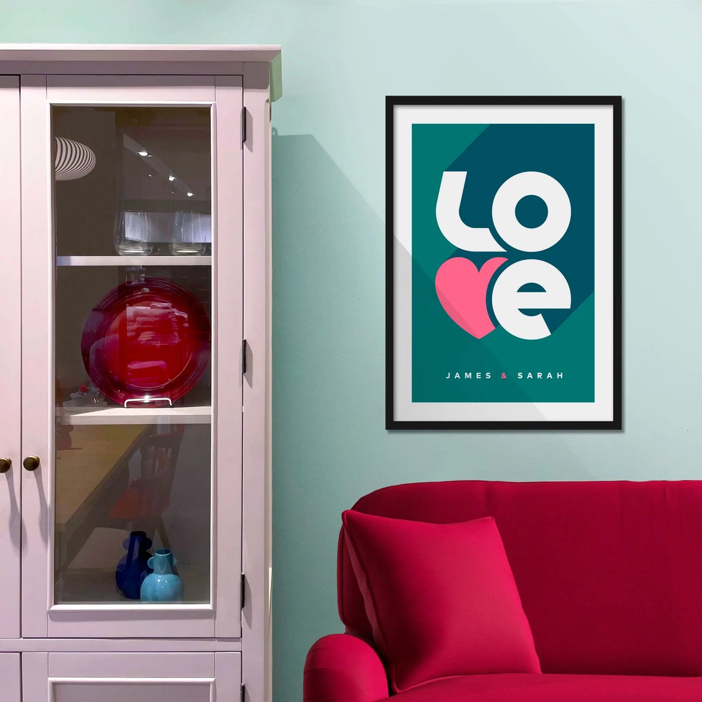 Framed picture on a baby blue wall beside pink shelving