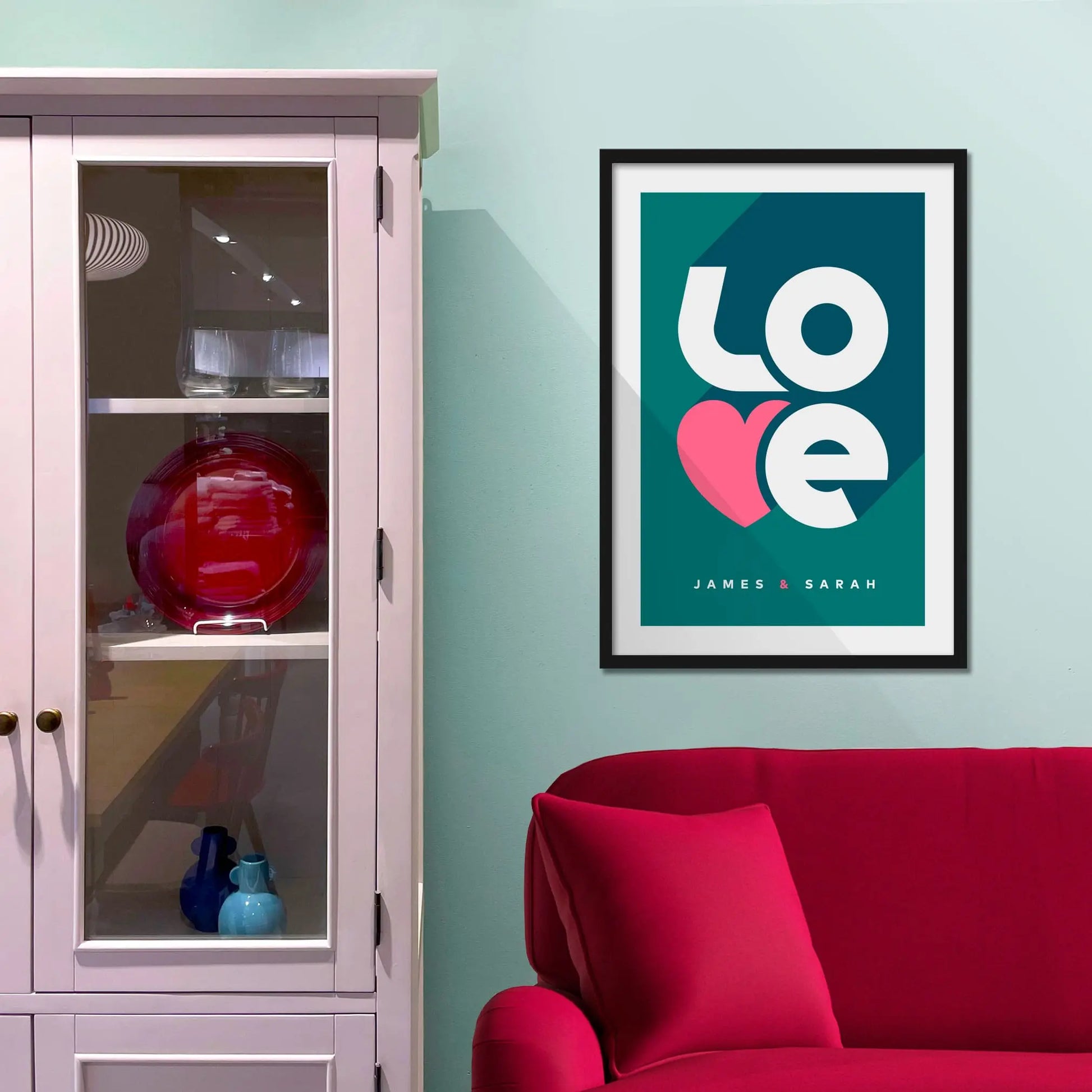 Framed picture on a baby blue wall beside pink shelving