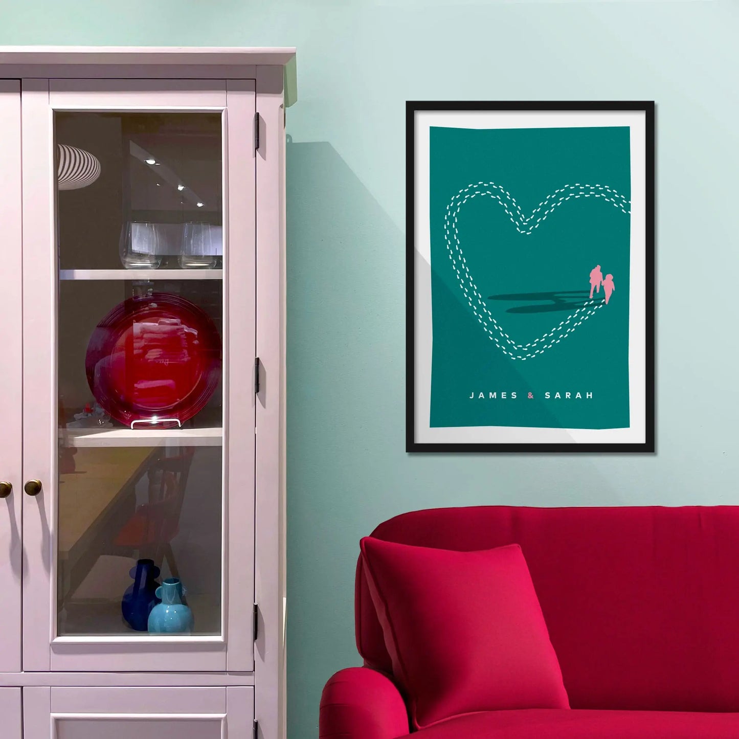 Framed picture on a baby blue wall beside pink shelving
