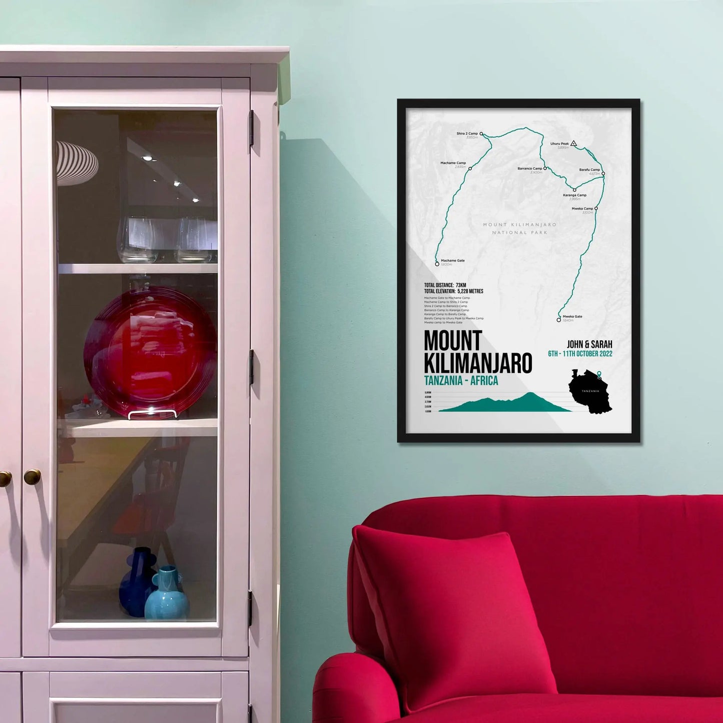 Framed picture on a baby blue wall beside pink shelving