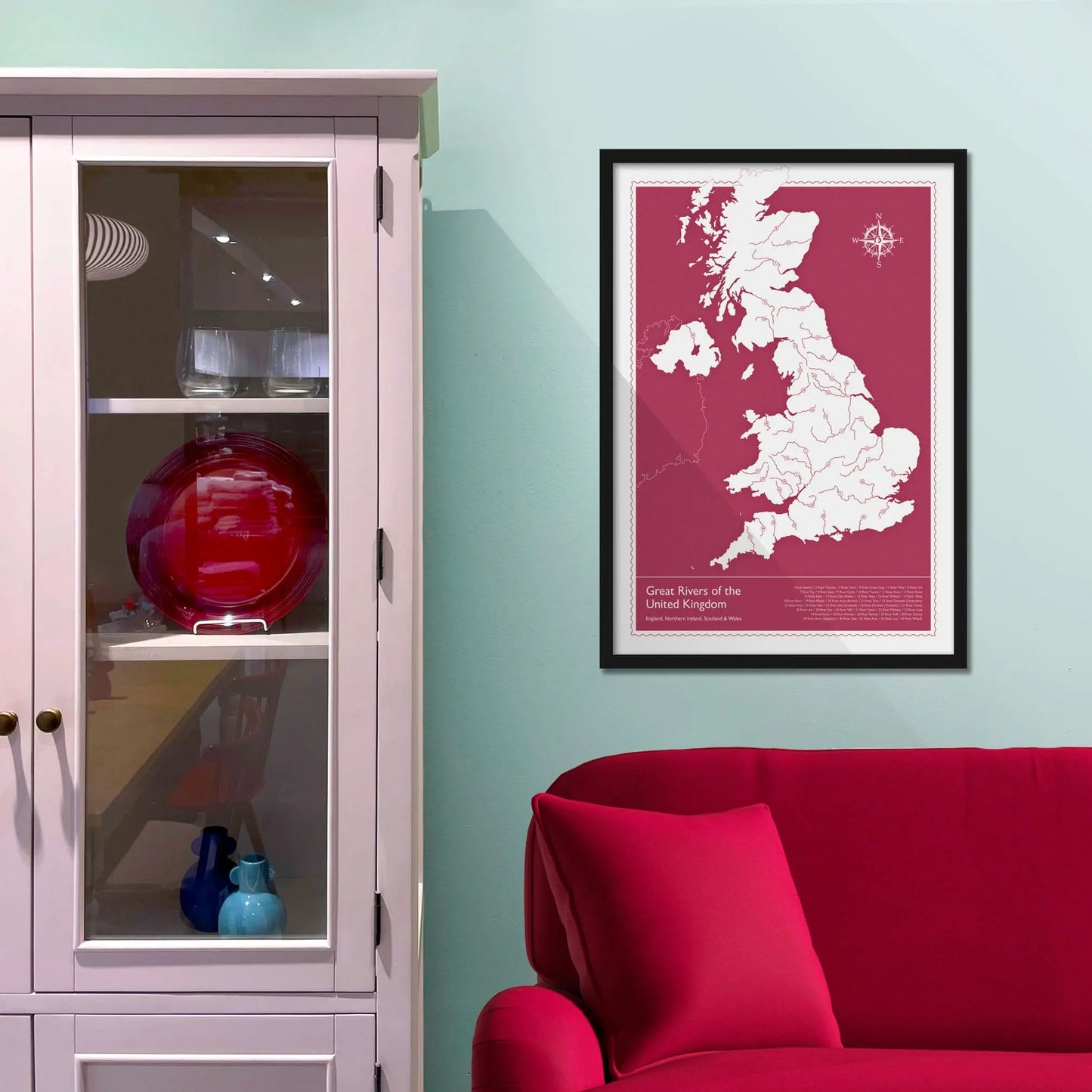 Framed picture on a baby blue wall beside pink shelving