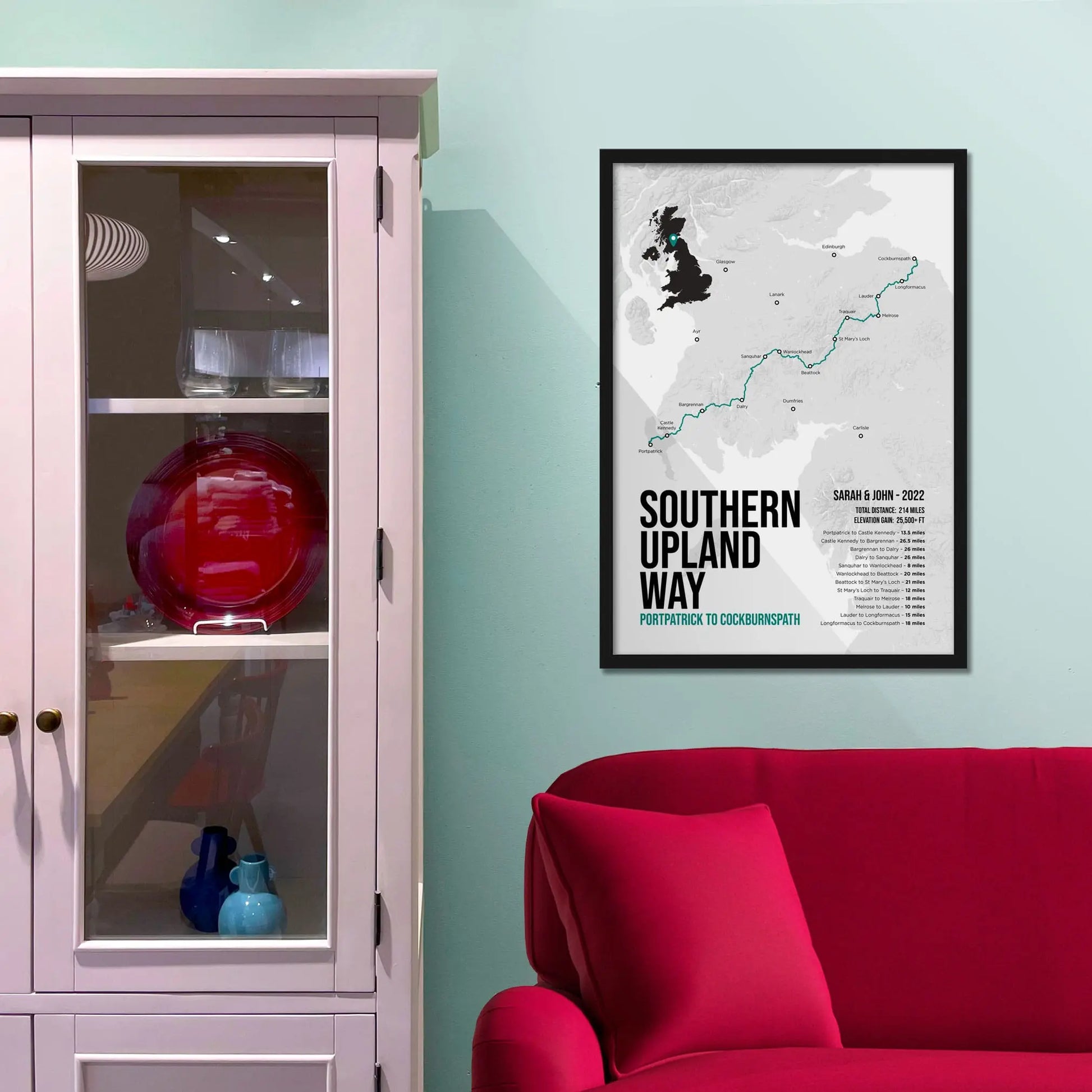 Framed print on light blue wall beside pink shelving unit.