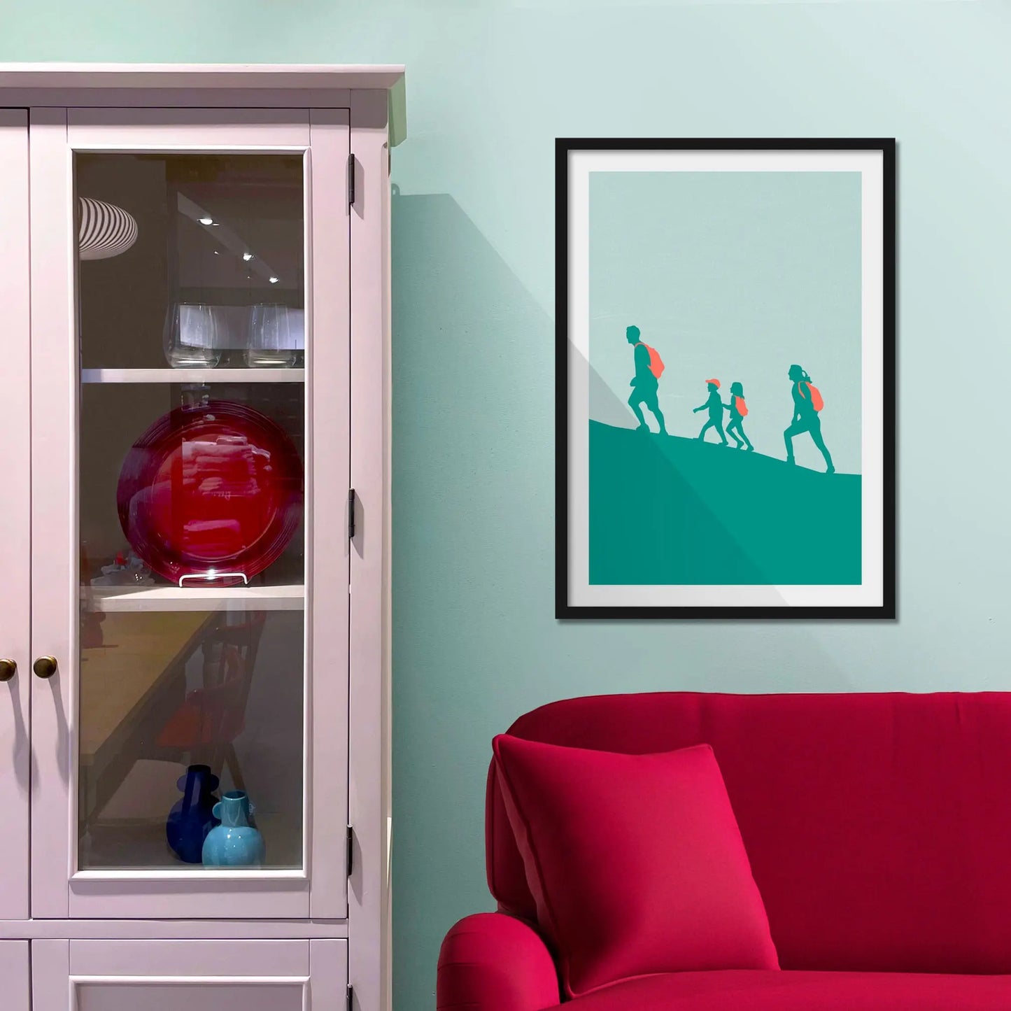 Framed picture on a baby blue wall beside pink shelving
