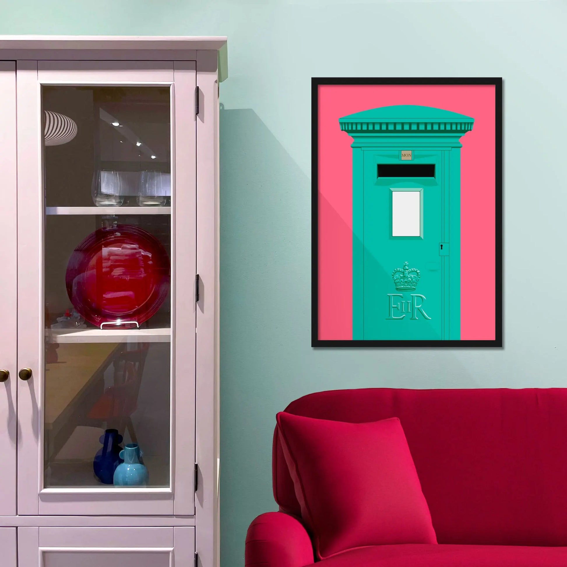 Framed picture on a baby blue wall beside pink shelving