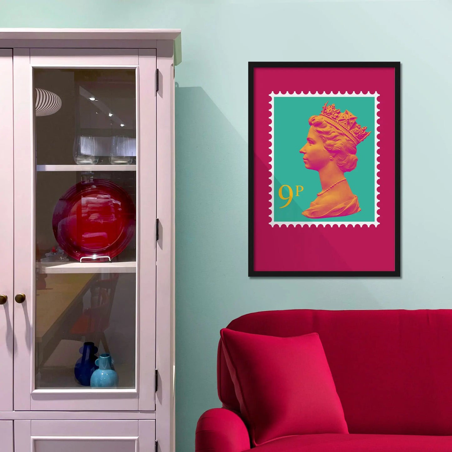 Framed picture on a baby blue wall beside pink shelving