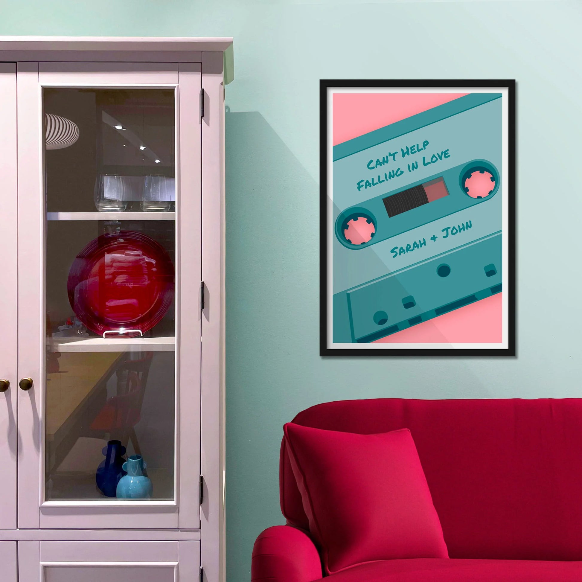 Framed picture on blue wall beside shelves above a red sofa