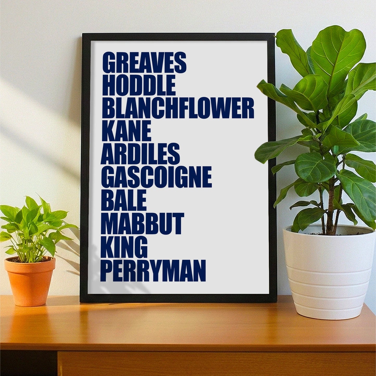 Framed print on sideboard beside a plant