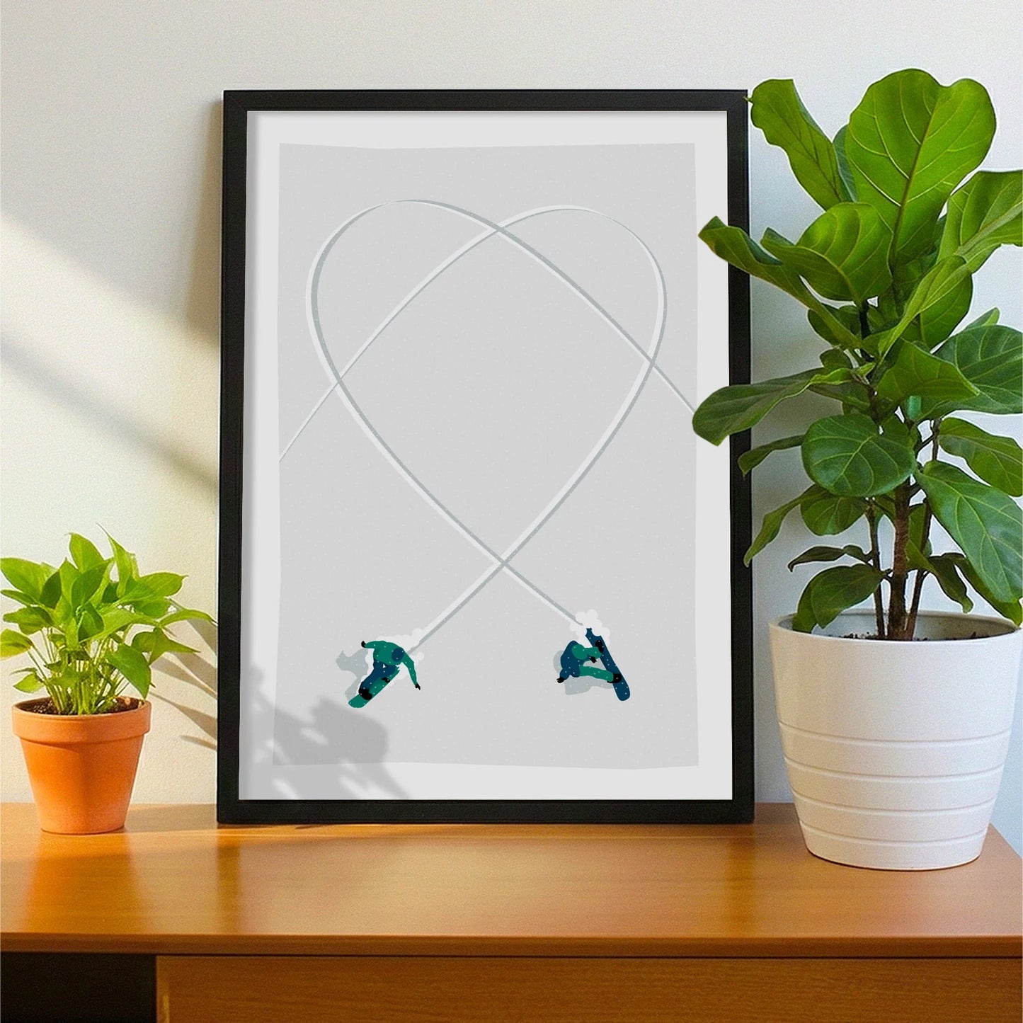 Framed print on sideboard beside a plant