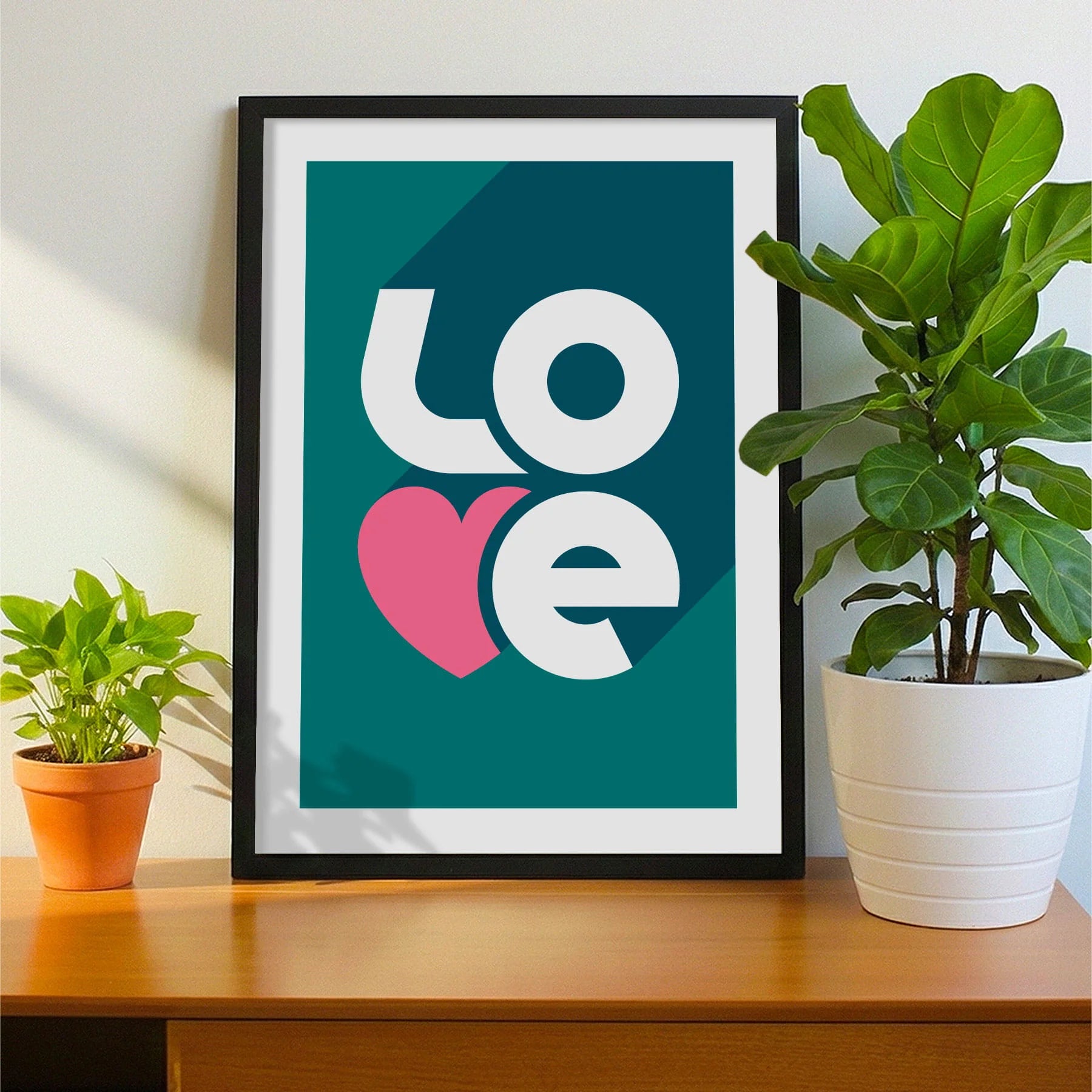 Framed print on sideboard beside a plant