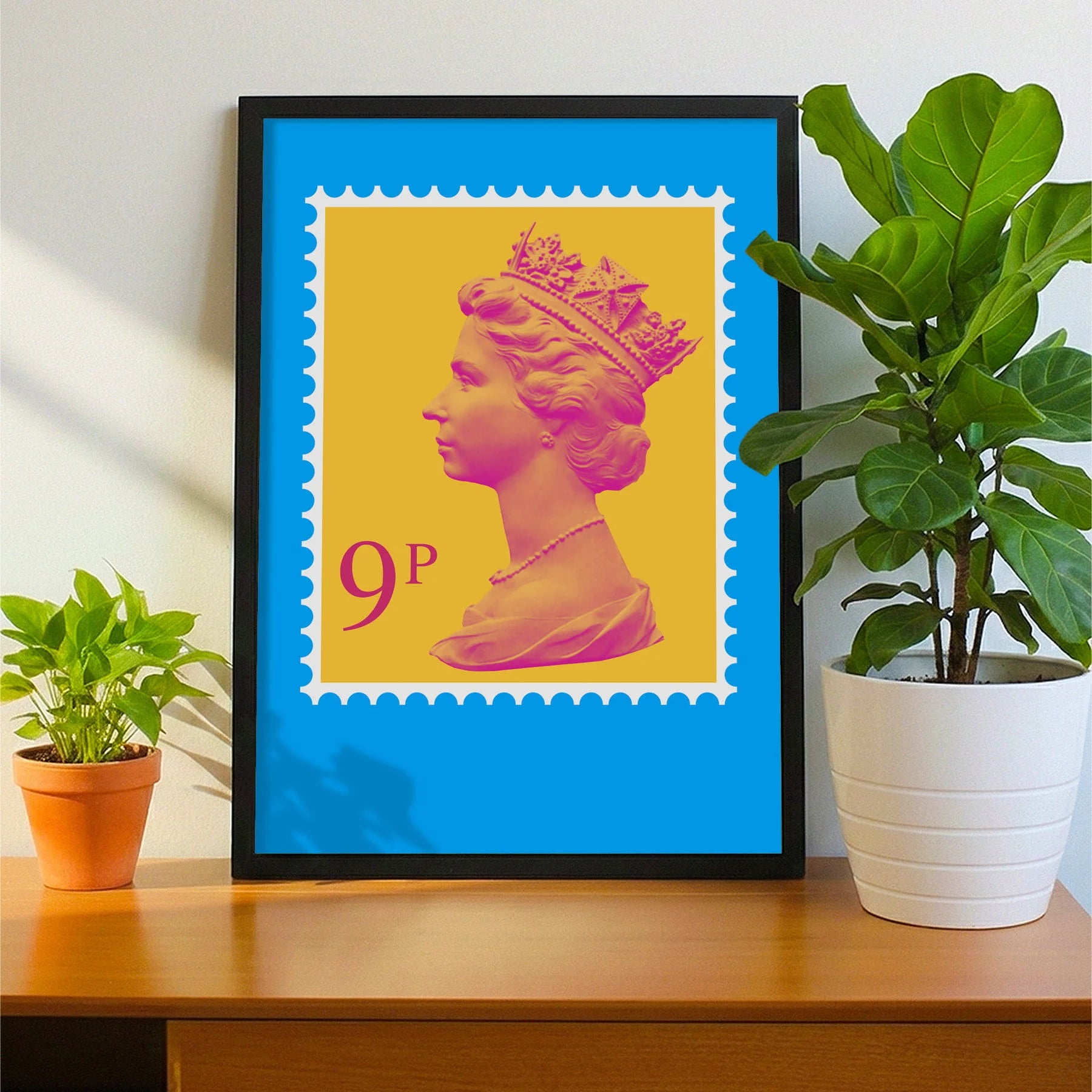 Framed print on sideboard beside a plant