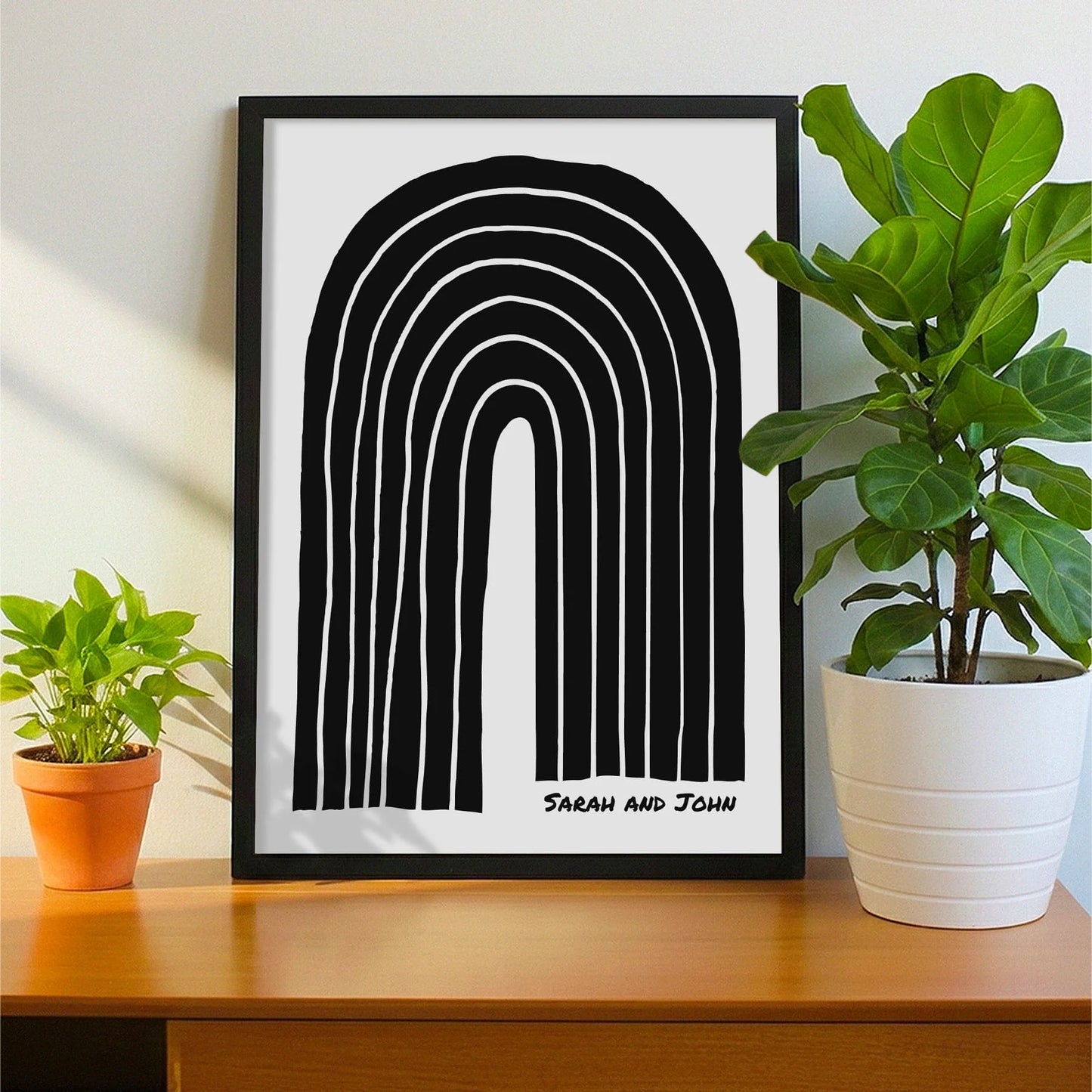 Framed print on sideboard beside a plant