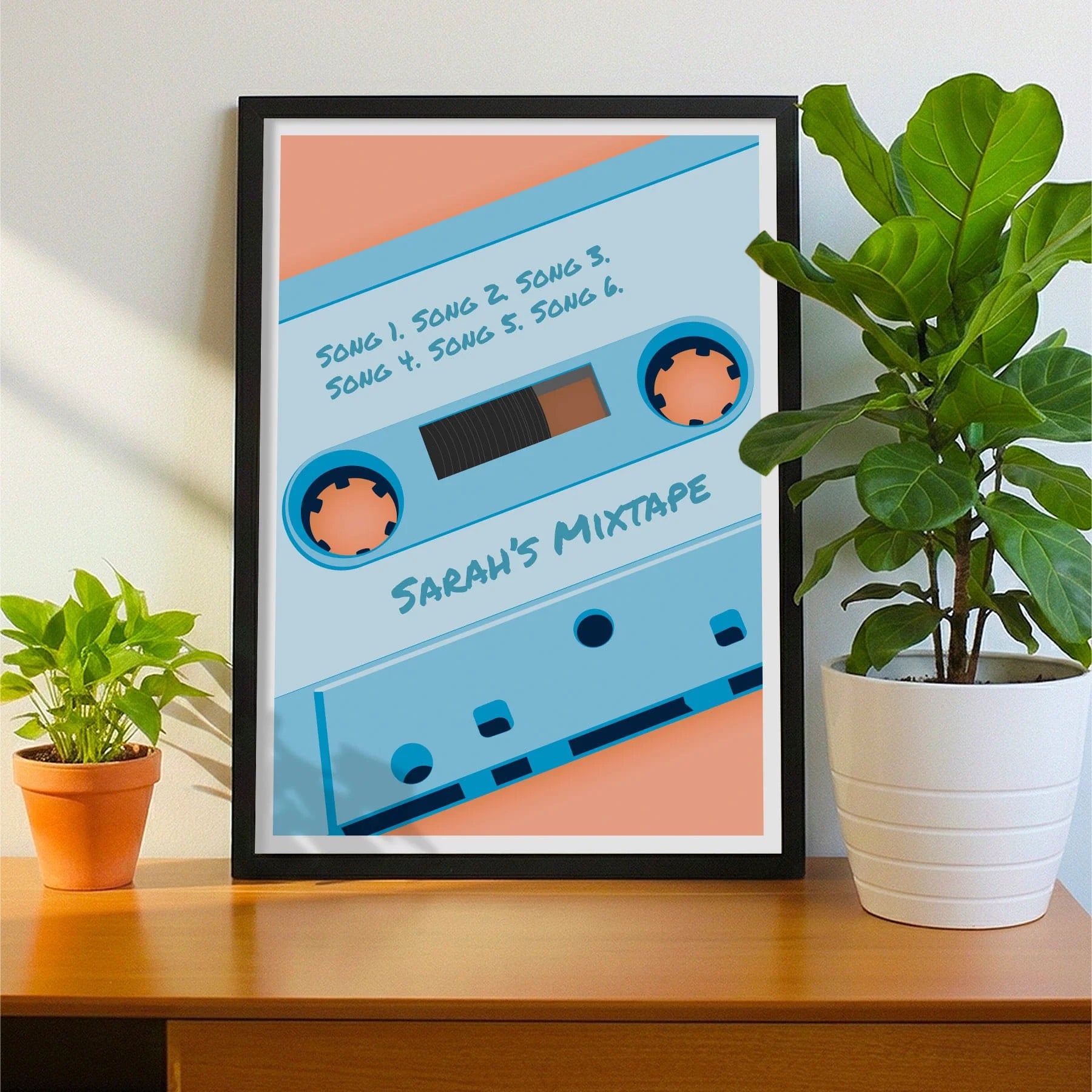 Framed print on sideboard beside a plant