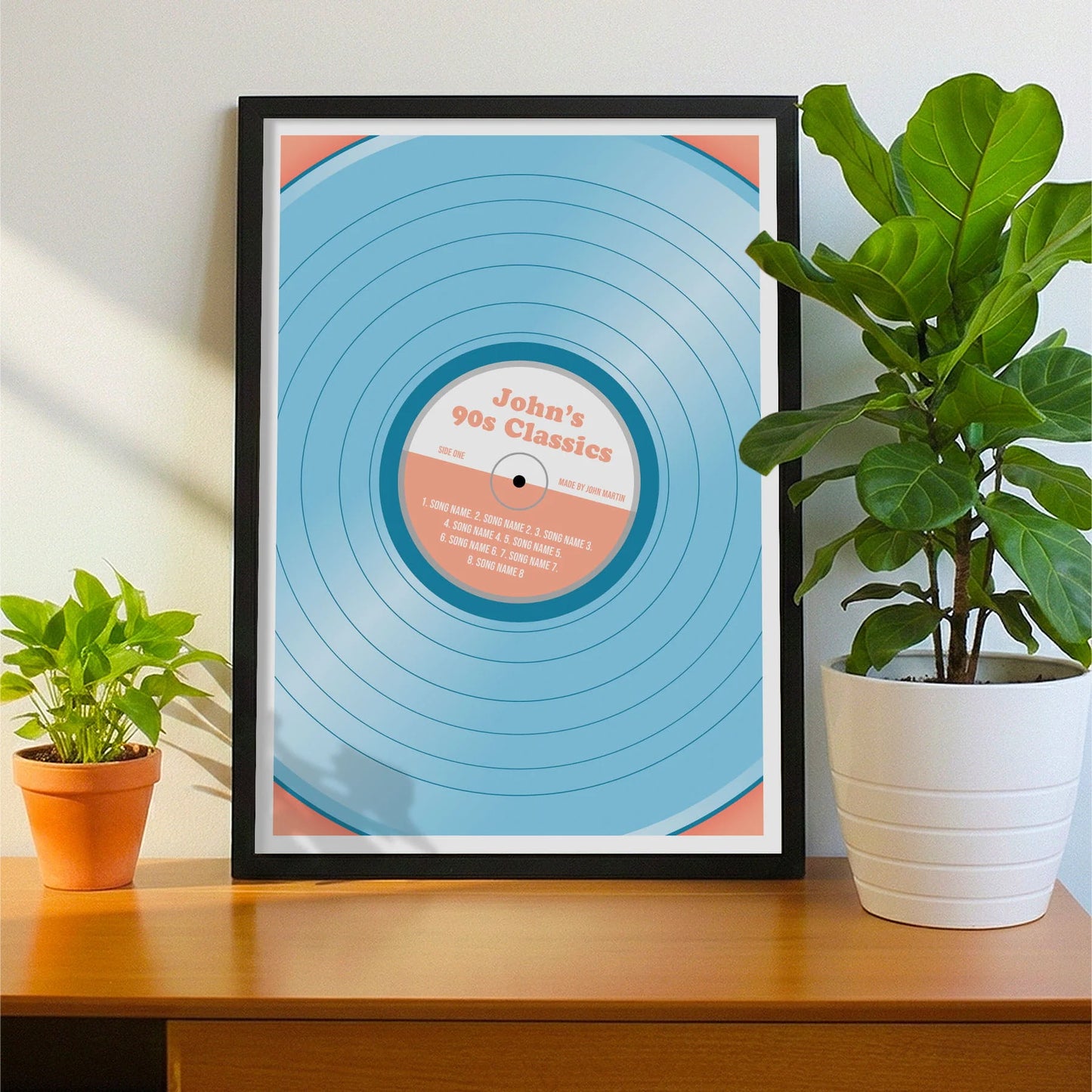 Framed print on sideboard beside a plant