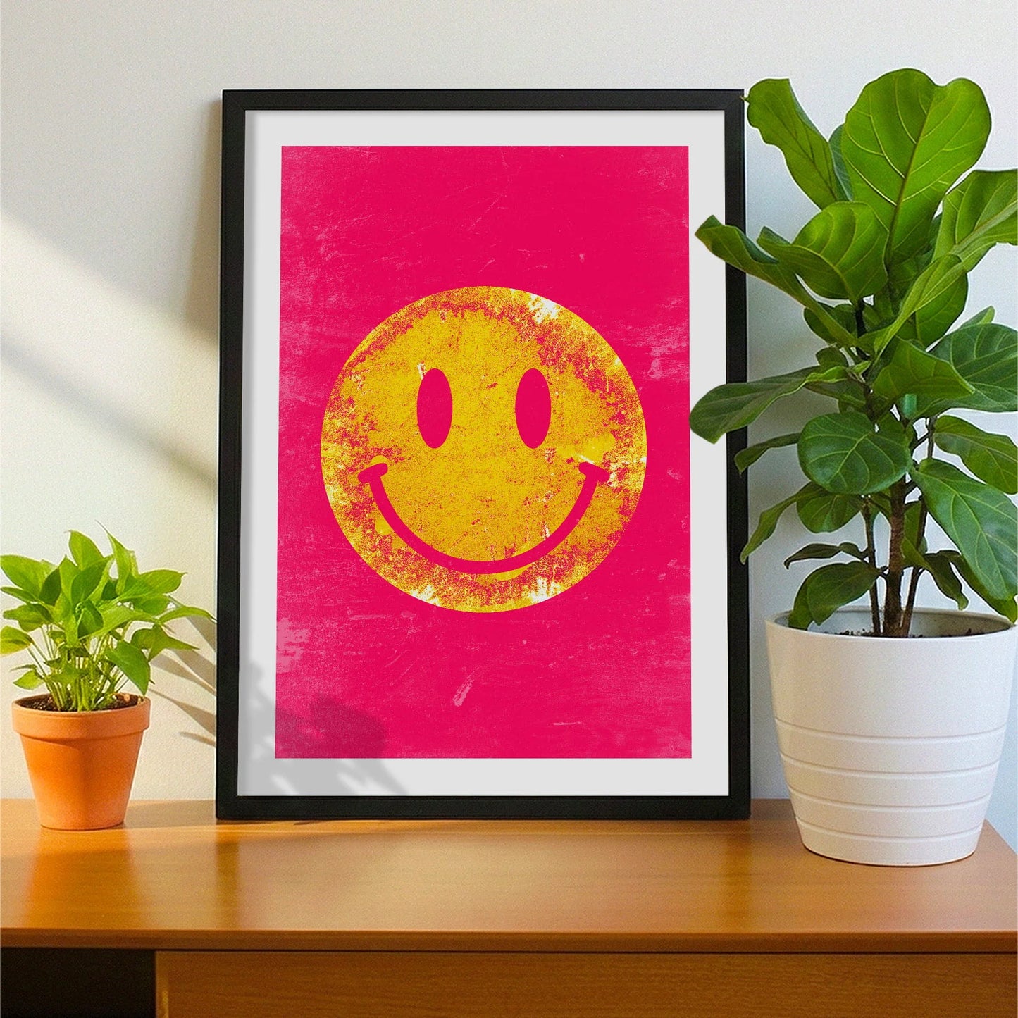 Framed print on sideboard beside a plant