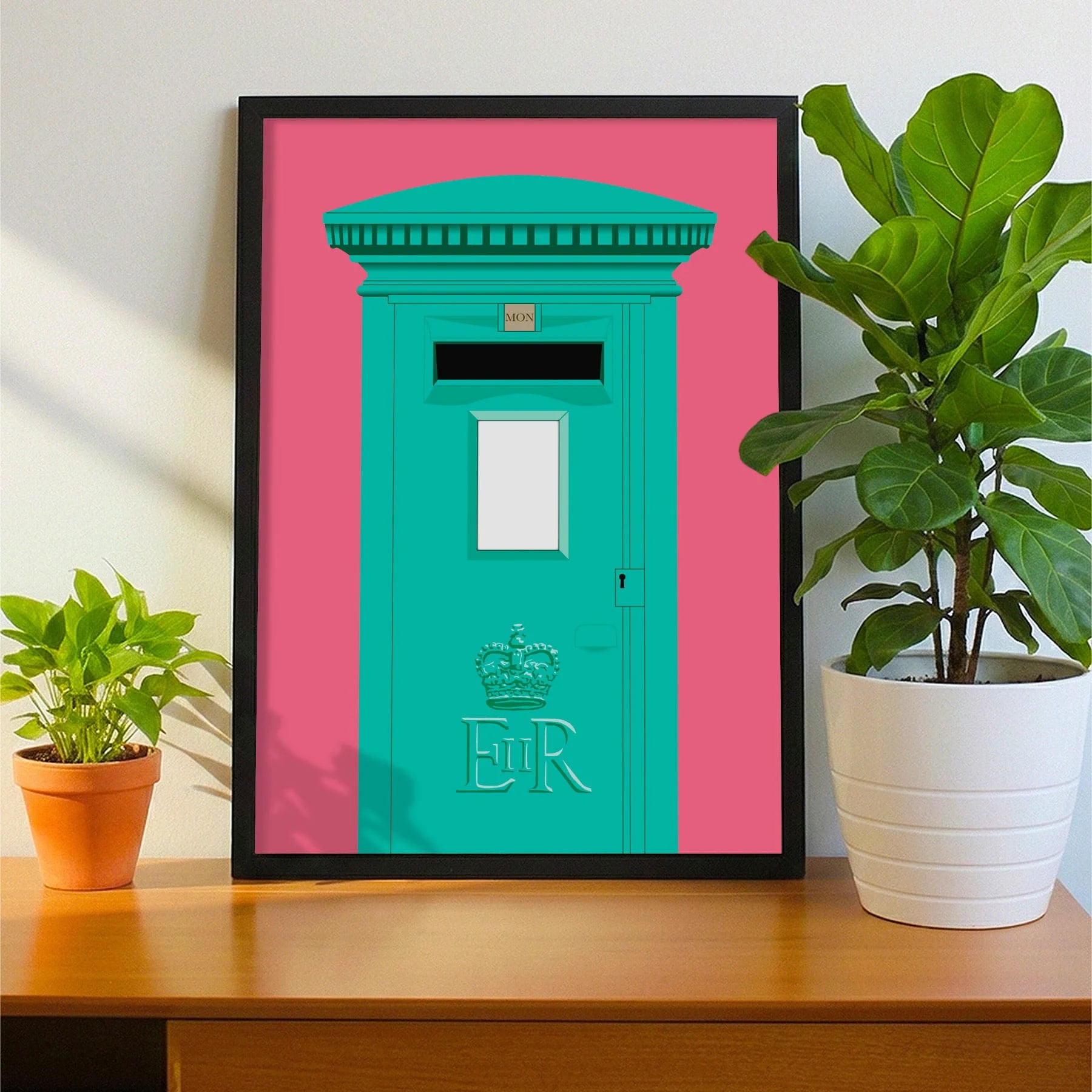 Framed print on sideboard beside a plant