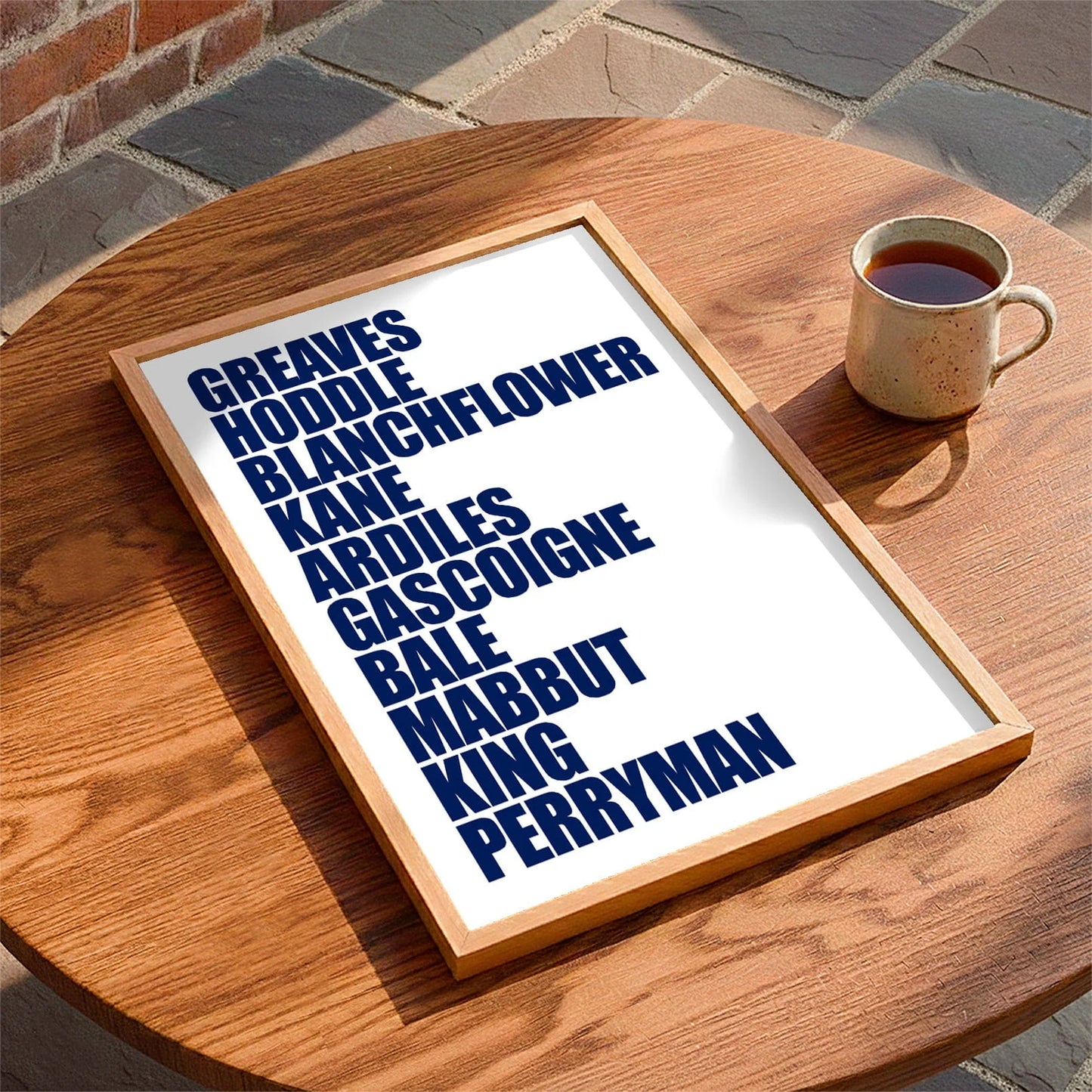 Framed print laying on a table beside a mug of tea