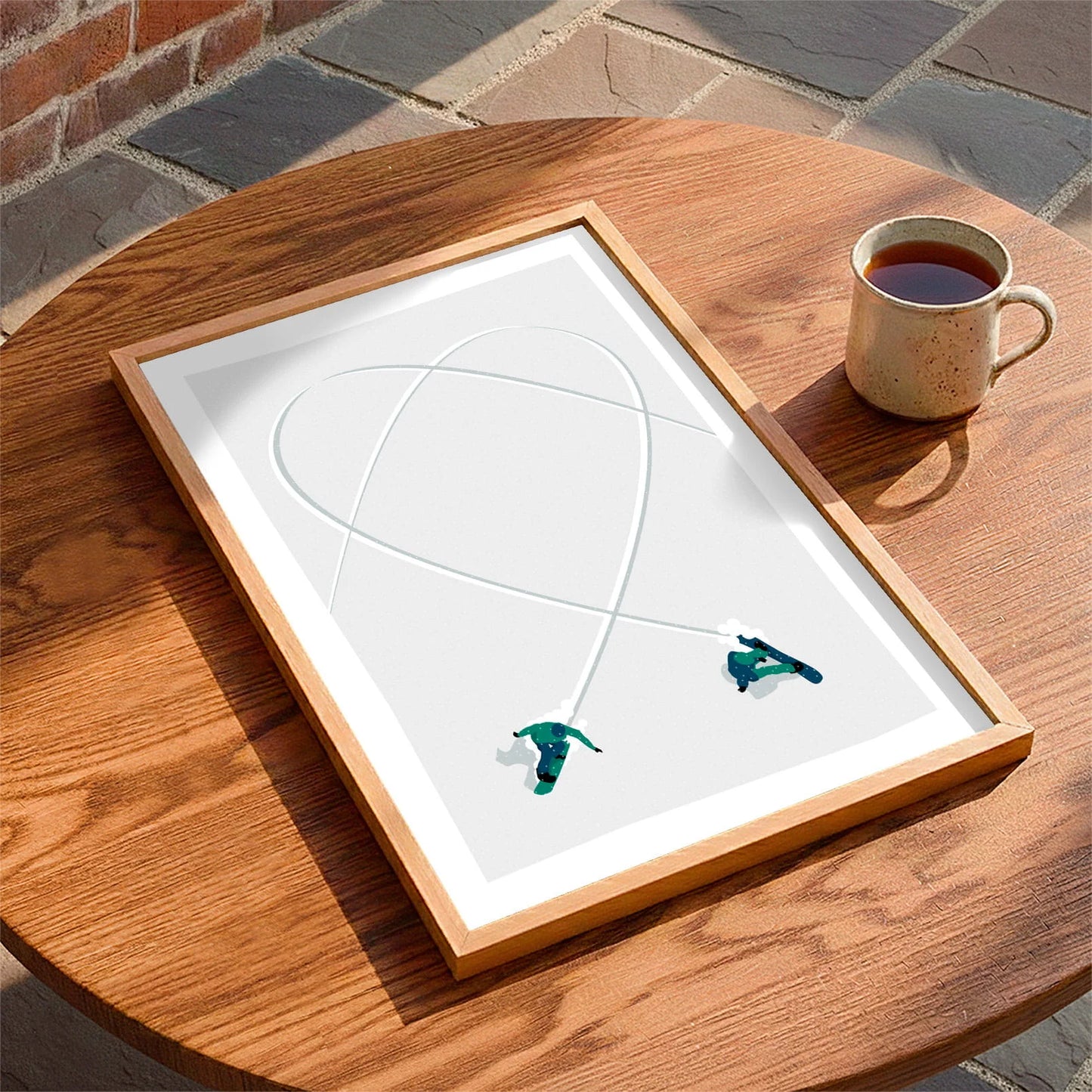 Framed print laying on a table beside a mug of tea