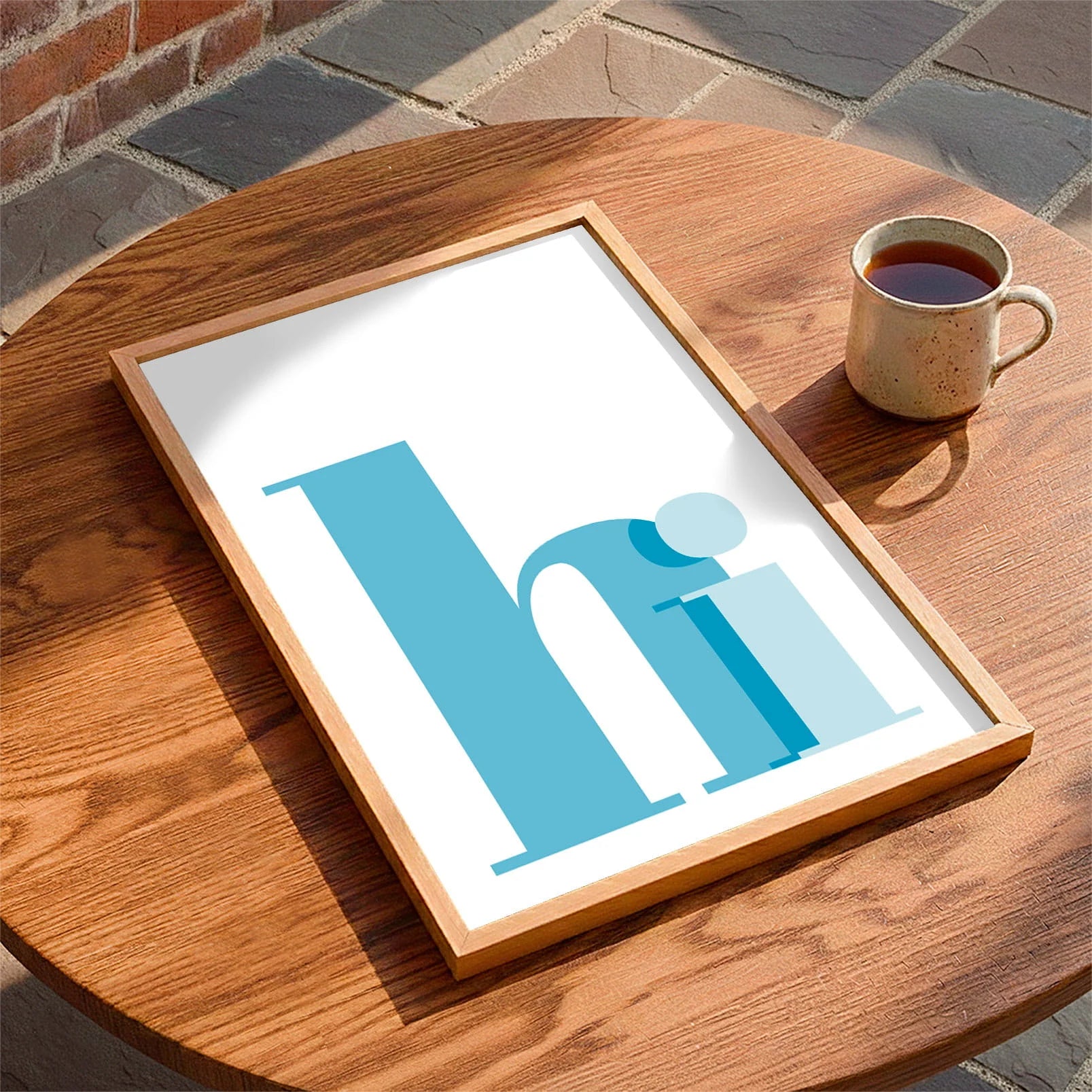 Framed print laying on a table beside a mug of tea