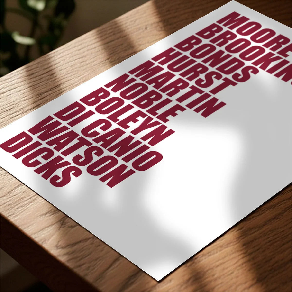 Print laying on table with speckled shade cast across the surface