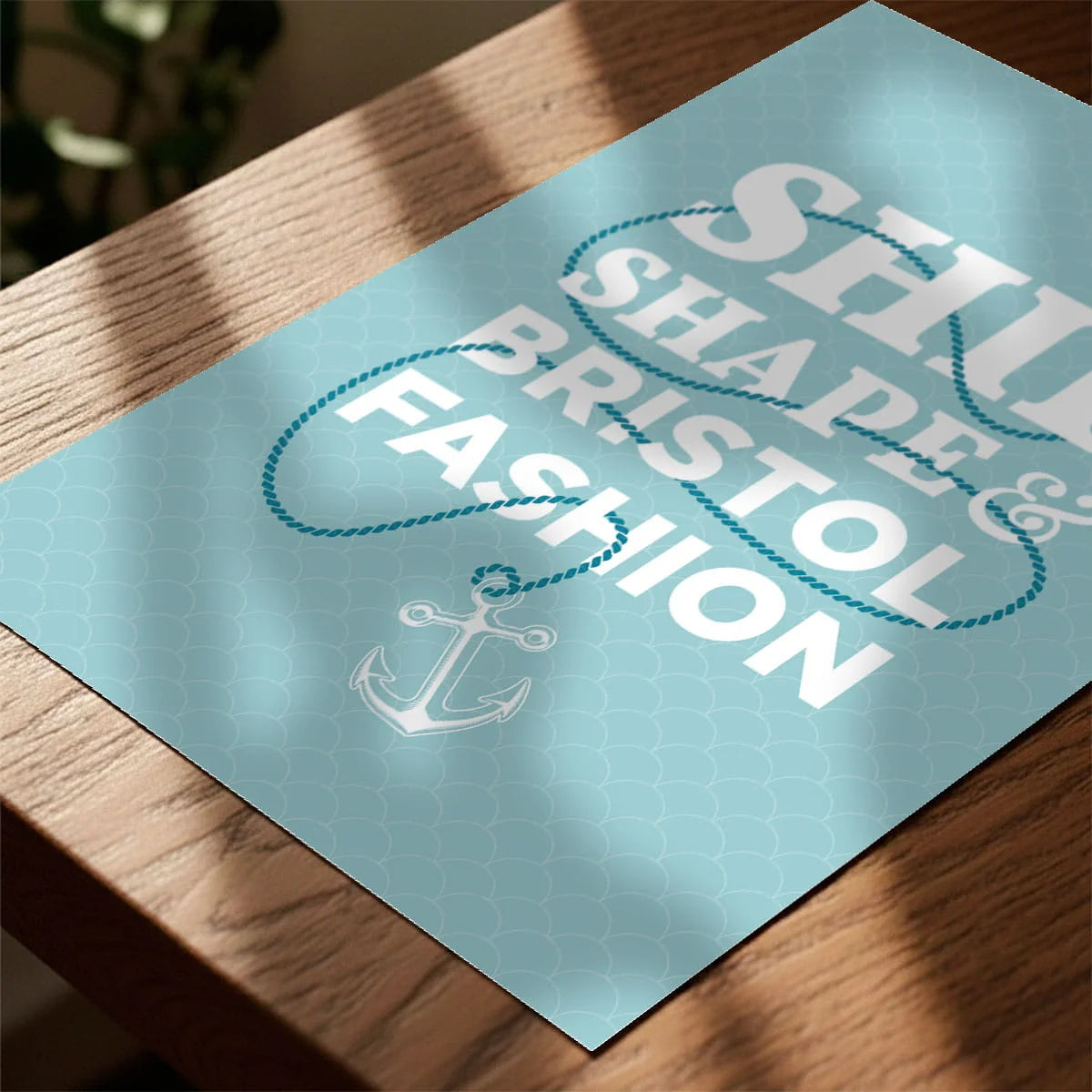 Print laying on table with speckled shade cast across the surface