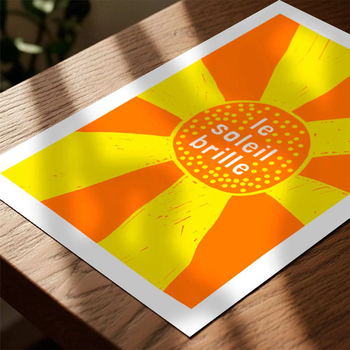 Print laying on table with speckled shade cast across the surface