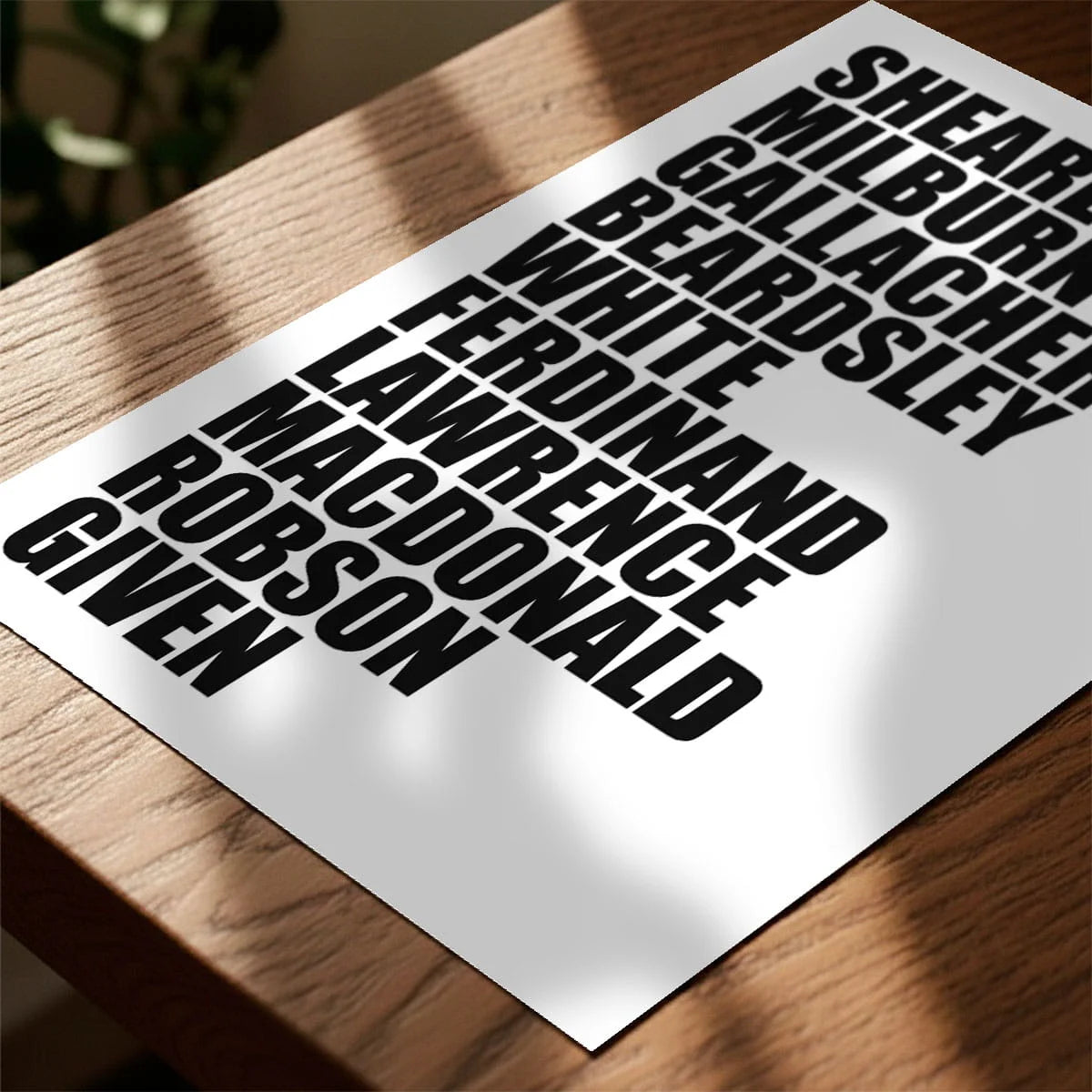 Print laying on table with speckled shade cast across the surface