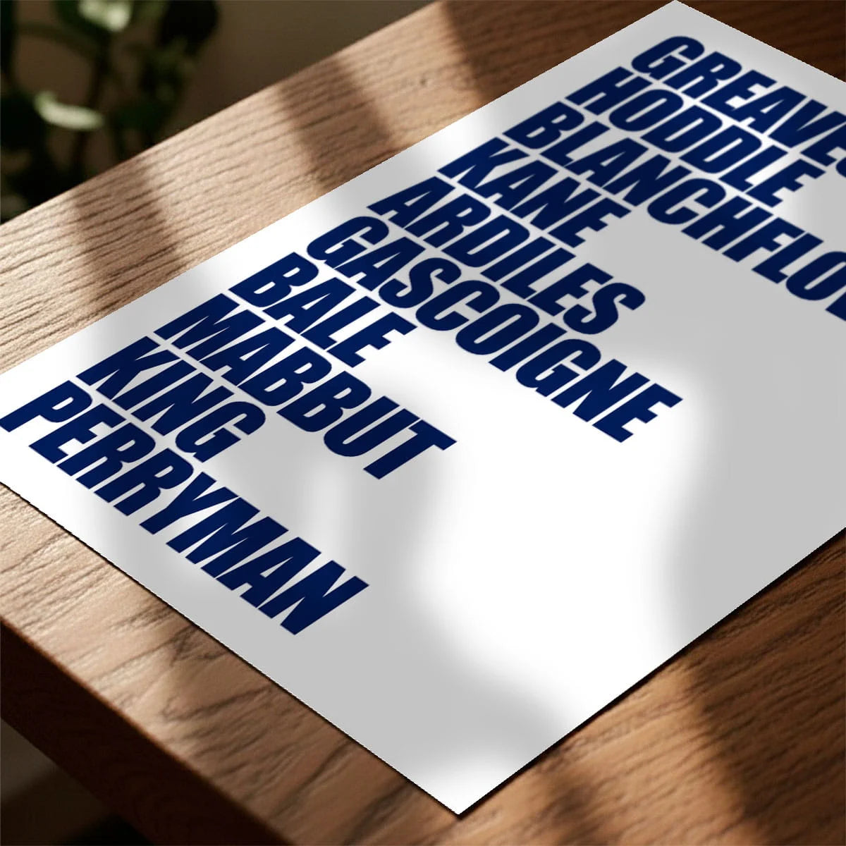 Print laying on table with speckled shade cast across the surface