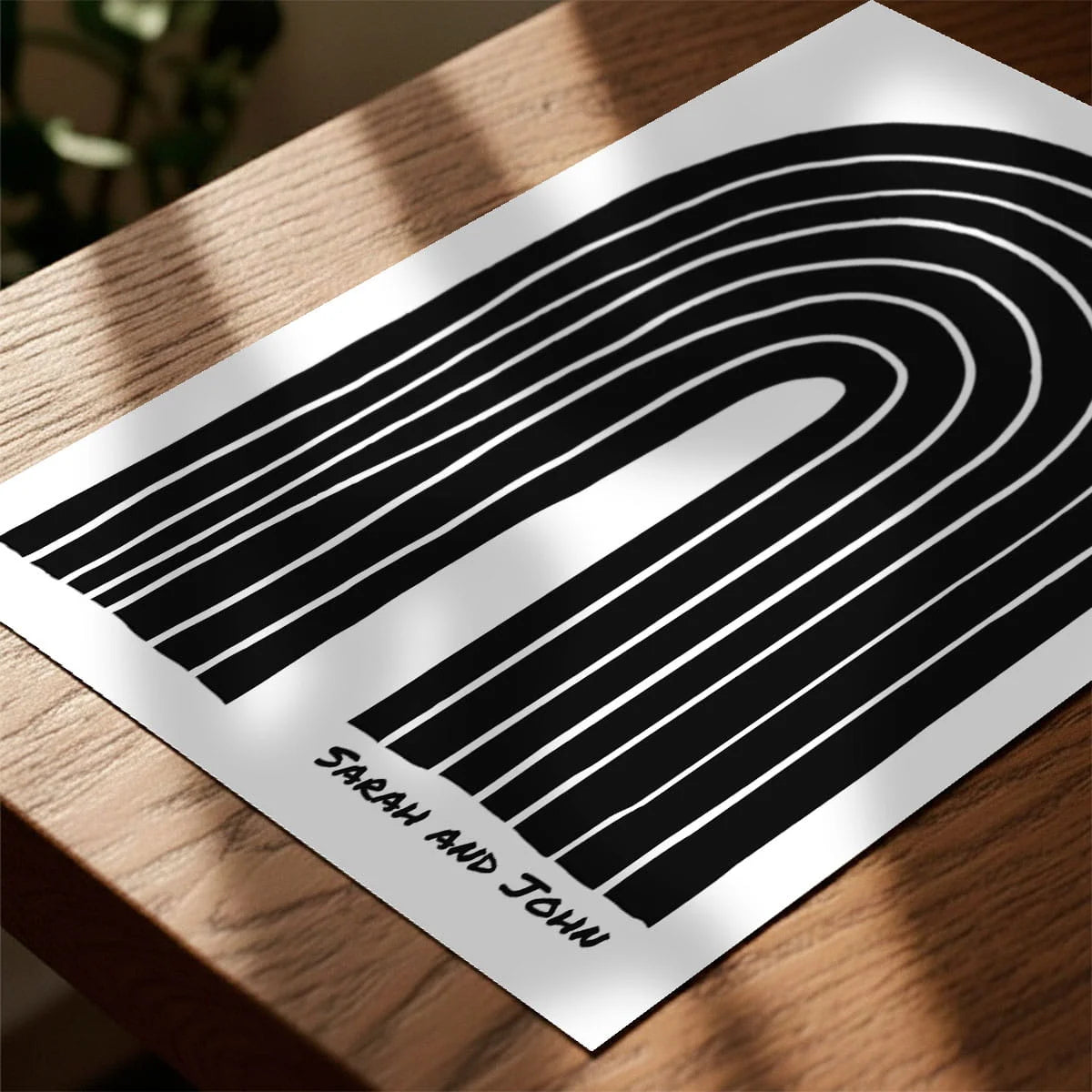 Print laying on table with speckled shade cast across the surface